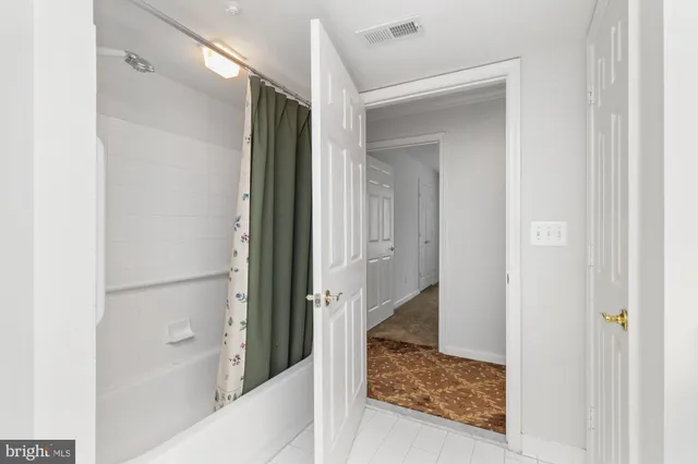a bedroom with a bed and a flat tv screen on dresser