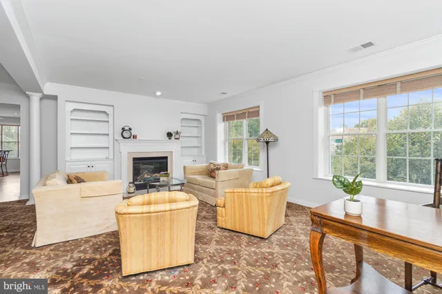 a living room with furniture a fireplace and a chandelier
