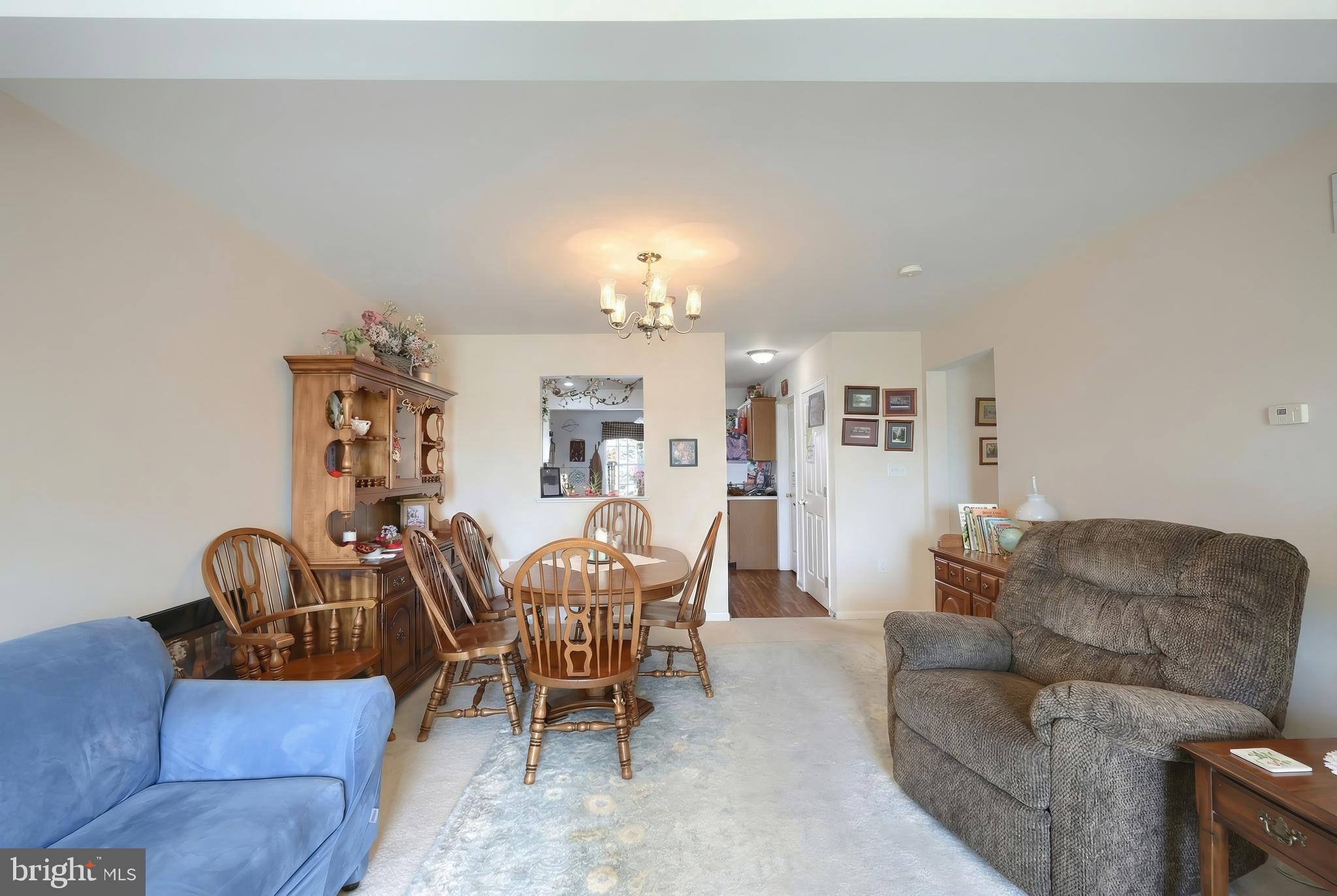 39 Spring Hill Lane Mountville, PA 17554 - Photo 9 of 28 a living room with furniture a dining table and a chandelier