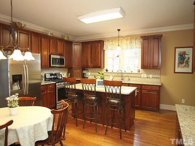 236 Release Circle Raleigh, NC 27615 - Photo 9 of 25 a kitchen with granite countertop wooden floors a center island and appliances