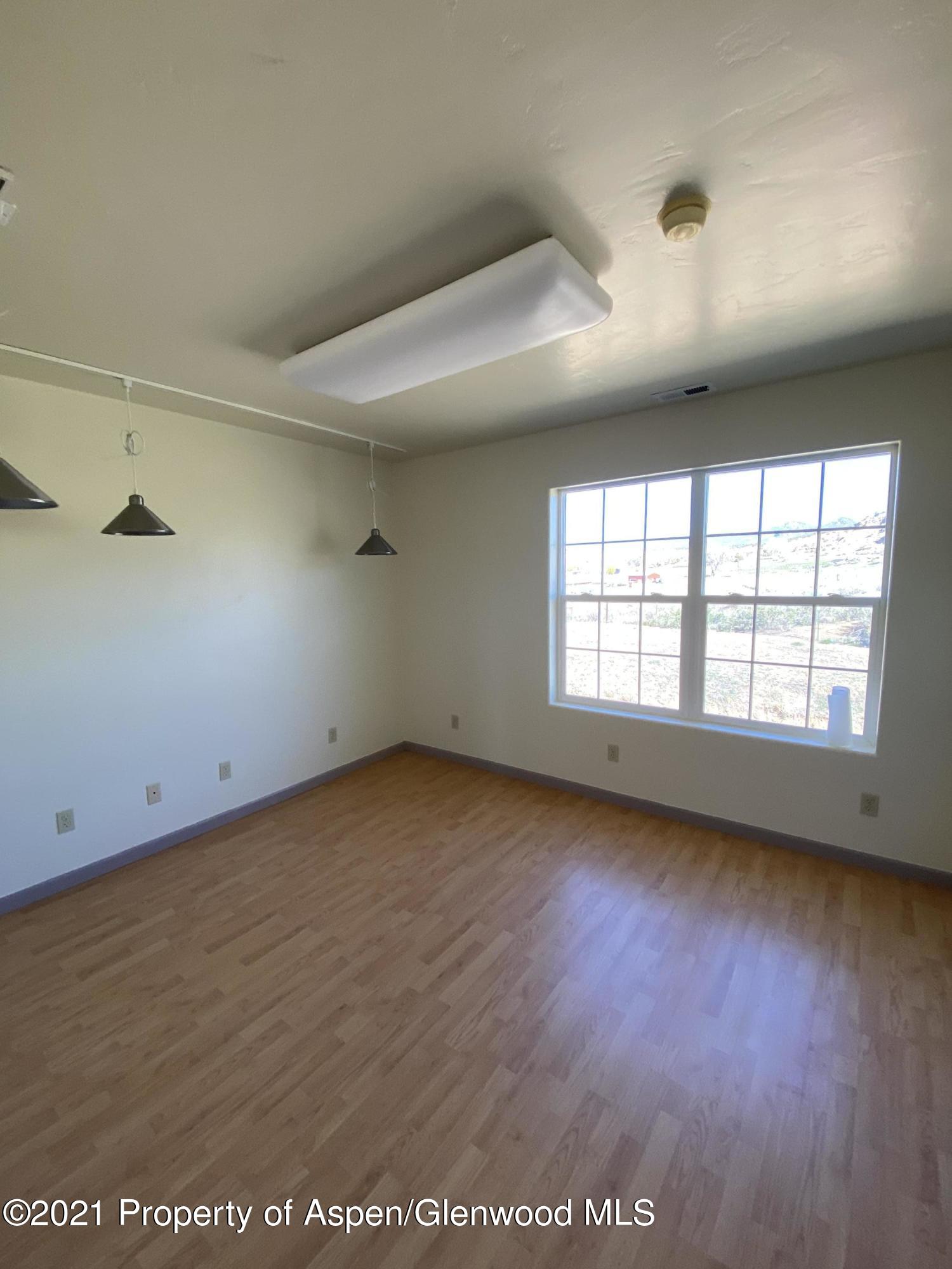 658 Cindys Way Rifle, CO 81650 - Photo 15 of 30 an empty room with wooden floor and windows