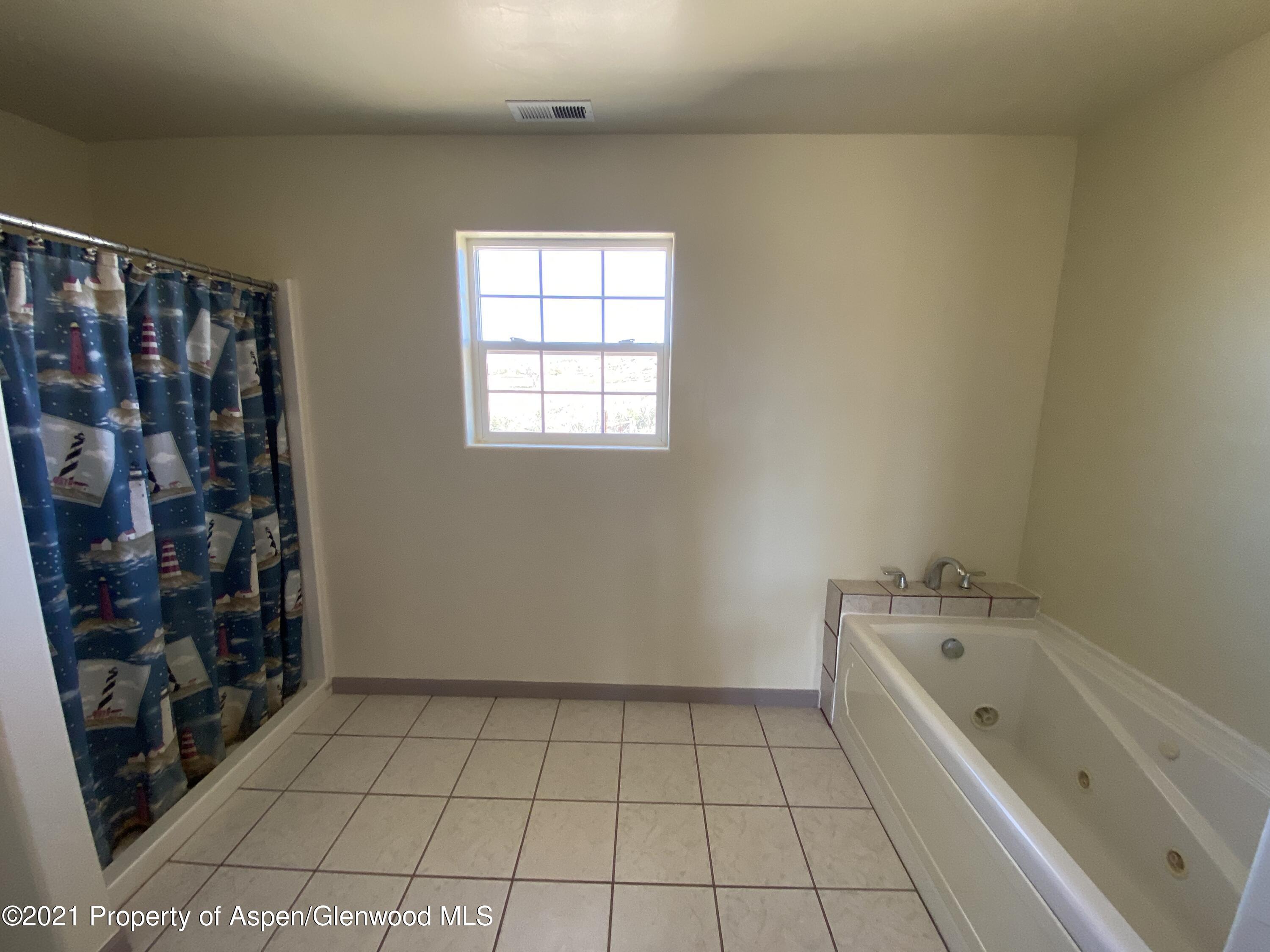658 Cindys Way Rifle, CO 81650 - Photo 20 of 30 a spacious bathroom with a bathtub and a shower