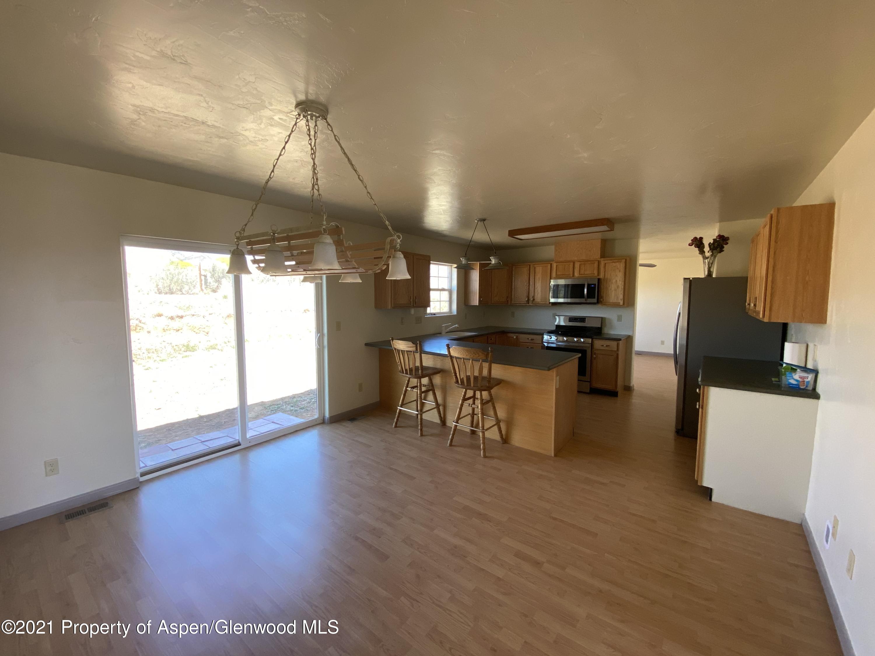 658 Cindys Way Rifle, CO 81650 - Photo 4 of 30 a kitchen with stainless steel appliances kitchen island granite countertop a refrigerator a stove top oven a sink and dishwasher