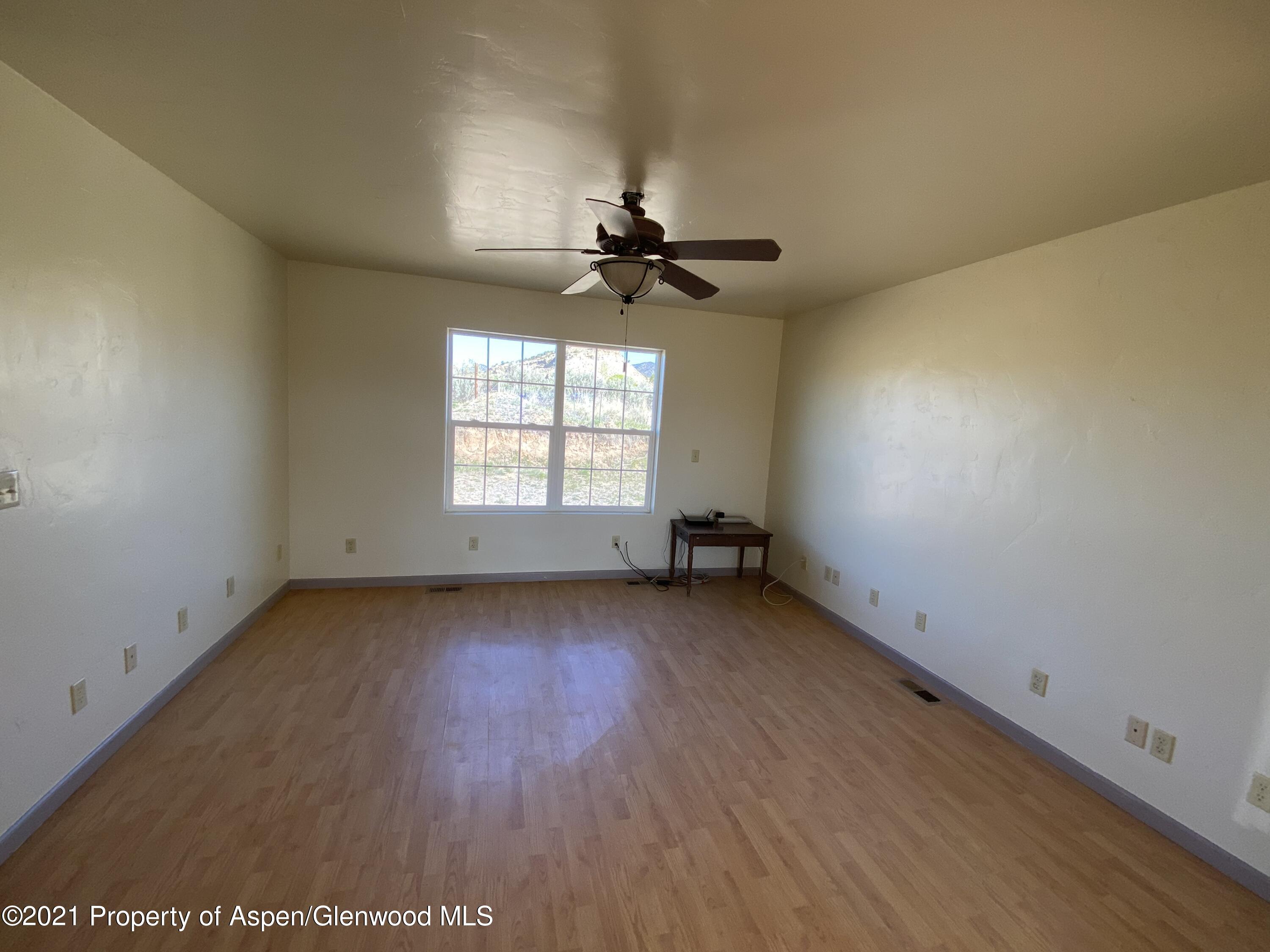 658 Cindys Way Rifle, CO 81650 - Photo 10 of 30 an empty room with a window and a ceiling fan