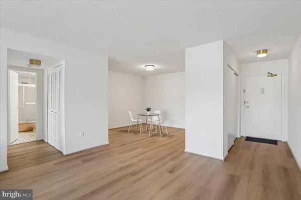 a view of a room with wooden floor table and chairs