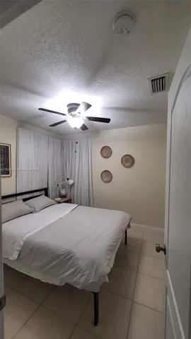 a spacious bedroom with a bed and a chandelier