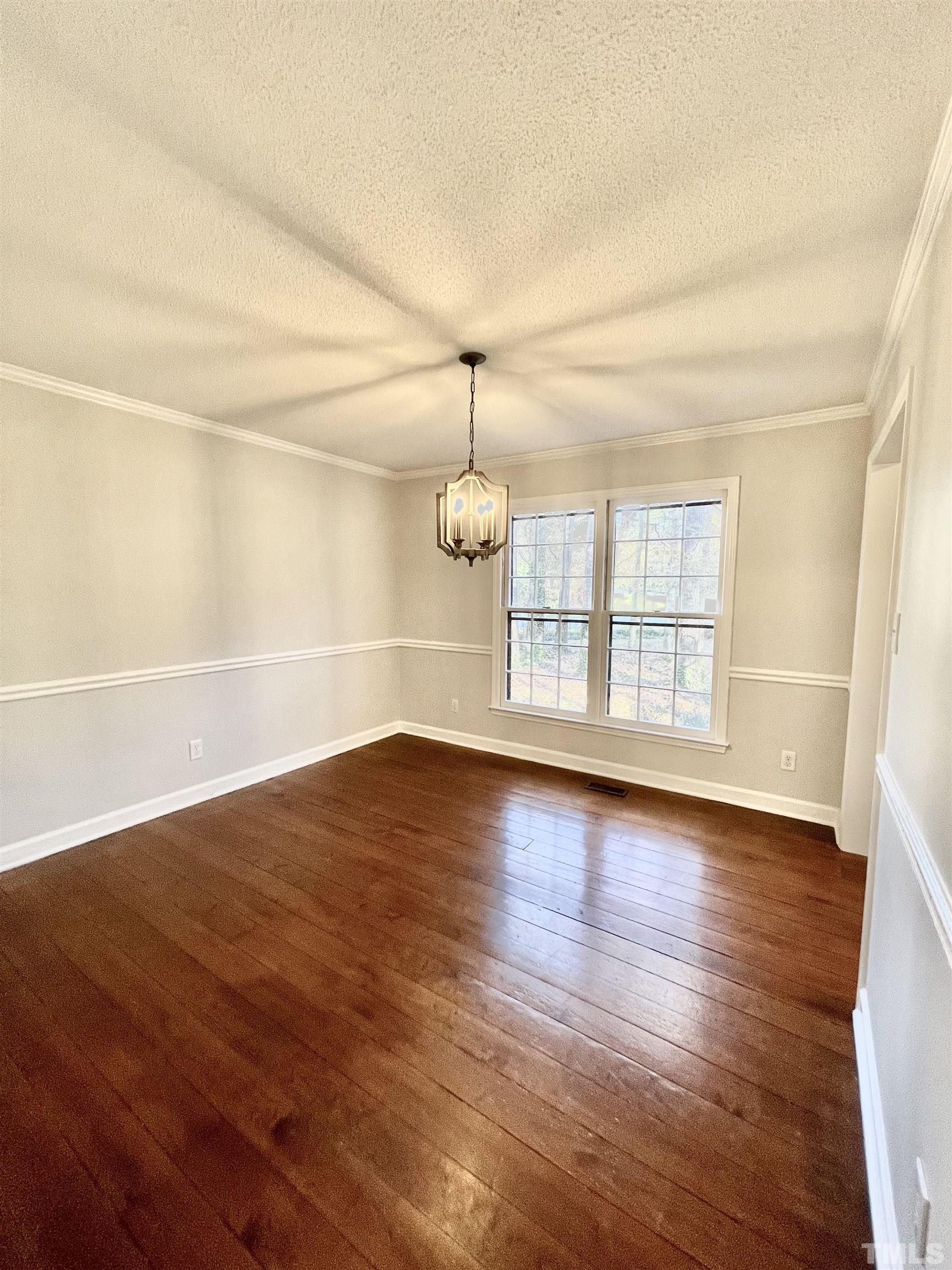 3101 Paxton Place Raleigh, NC 27613 - Photo 8 of 28 an empty room with wooden floor and windows