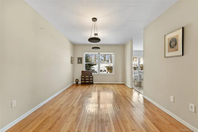 a view of a room with wooden floor a ceiling fan and windows