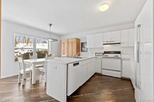 a kitchen with white cabinets and white appliances