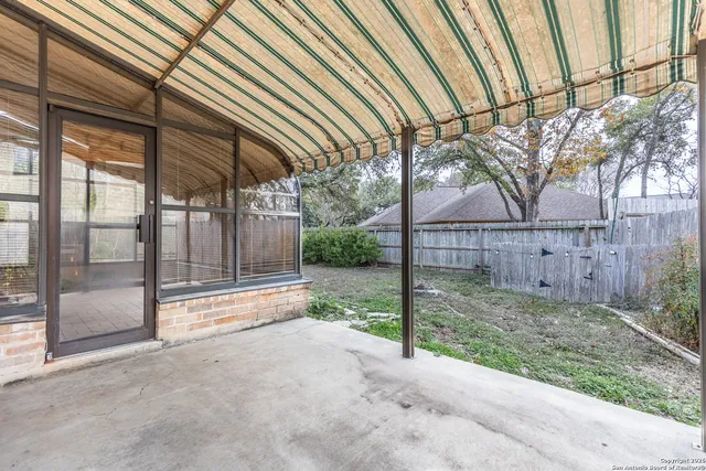a view of backyard with wooden fence and large trees