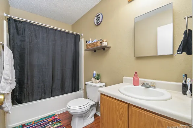 a bathroom with a sink a toilet and shower curtain