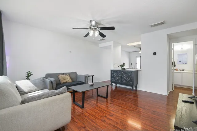 a living room with furniture and a wooden floor