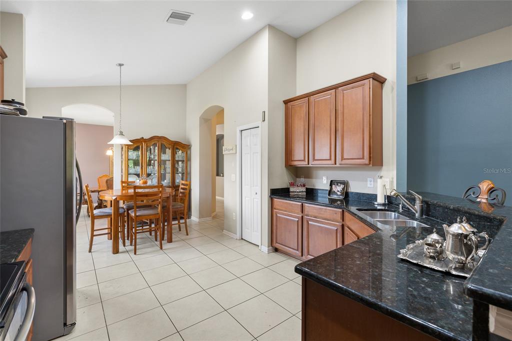 10925 Rockledge View Drive Riverview, FL 33579 - Photo 14 of 49 a kitchen with stainless steel appliances granite countertop a stove top oven a sink a dining table and chairs with wooden floor