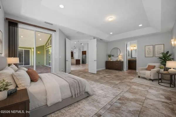 a spacious bedroom with a large bed and furniture
