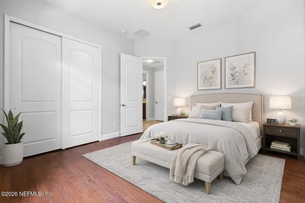 a spacious bedroom with a bed and a potted plant