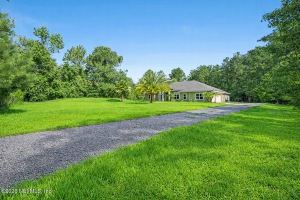 a view of green field with house in the background