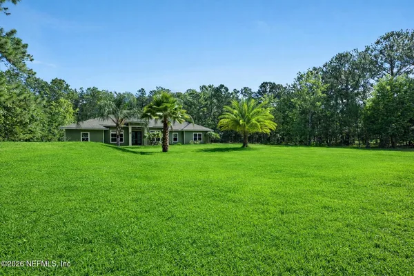 a view of a garden with a house in the background
