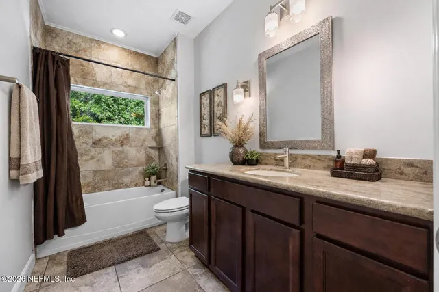 a bathroom with a granite countertop sink toilet mirror and bathtub