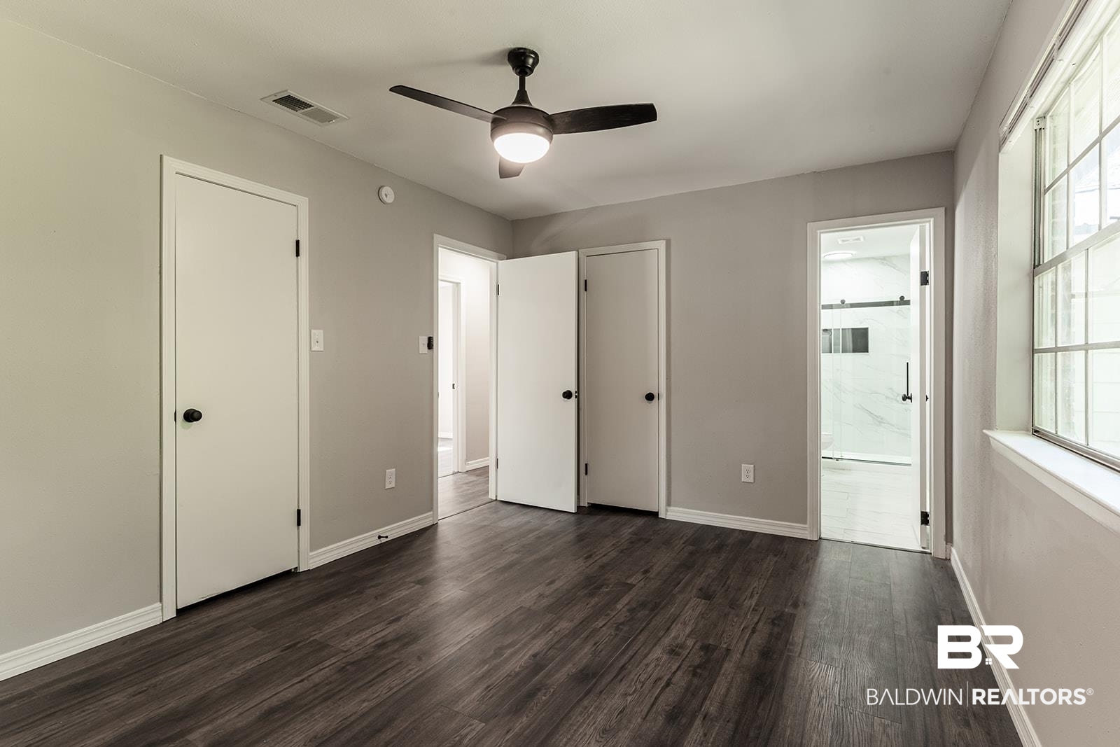 4626 Gold Drive Mobile, AL 36619 - Photo 24 of 48 Unfurnished bedroom with multiple windows, connected bathroom, ceiling fan, and dark hardwood / wood-style floors