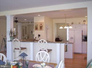 21 Mist Flower Road Berlin, MD 21811 - Photo 4 of 8 a view of a kitchen with kitchen island dining table and wooden floor