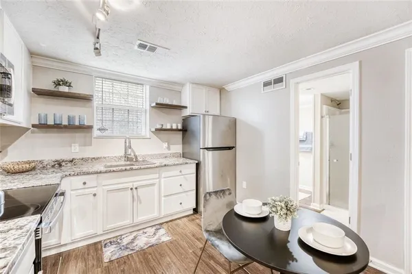 a kitchen with stainless steel appliances granite countertop a sink and a refrigerator