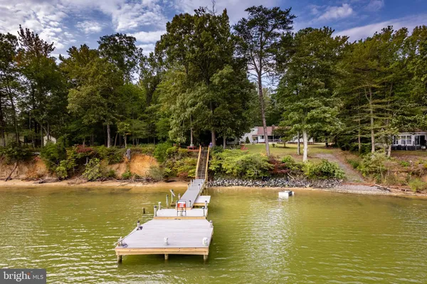 an aerial view of a house with a yard and lake view