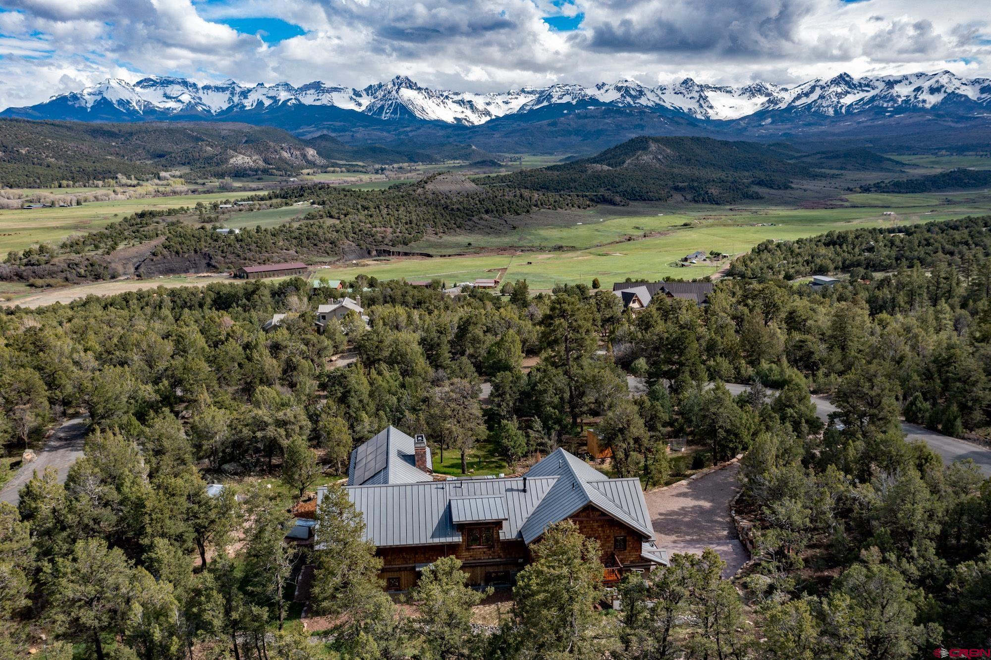 an aerial view of a house with a garden and mountain view