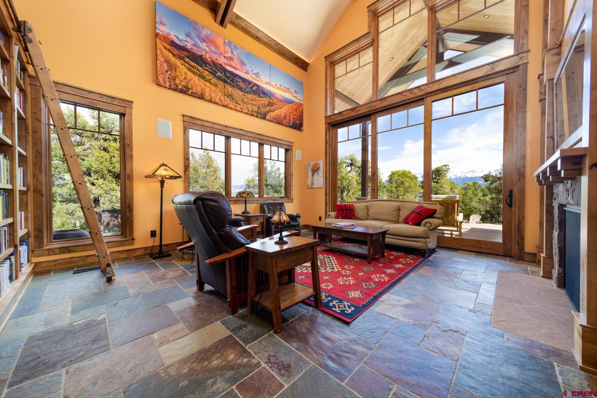 6534 Pleasant Point Drive Ridgway, CO 81432 - Photo 17 of 35 a living room with furniture floor to ceiling windows and a rug