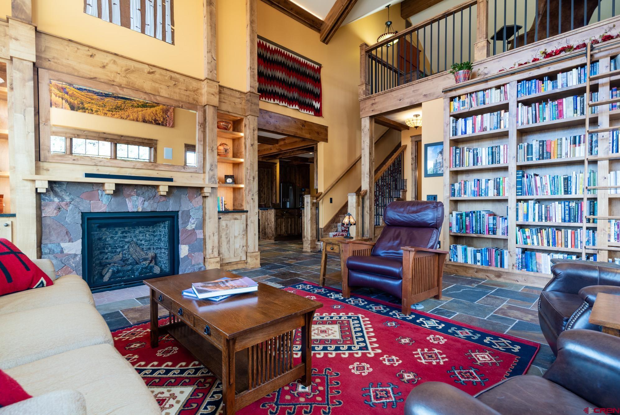 6534 Pleasant Point Drive Ridgway, CO 81432 - Photo 20 of 35 a living room with furniture a bookshelf and a fireplace