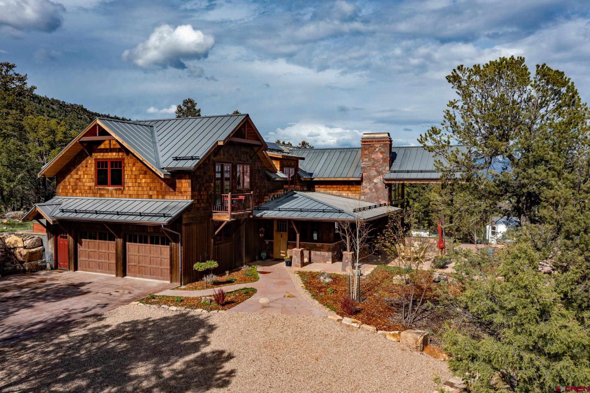 6534 Pleasant Point Drive Ridgway, CO 81432 - Photo 2 of 35 a backyard of a house with table and chairs under an umbrella