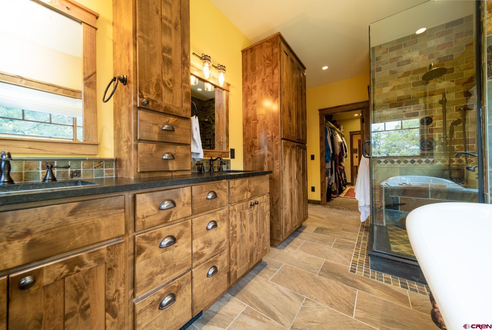 6534 Pleasant Point Drive Ridgway, CO 81432 - Photo 24 of 35 a spacious bathroom with a double vanity sink a mirror and a shower