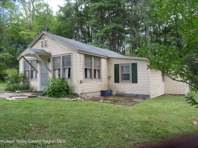 a kitchen with stainless steel appliances granite countertop a dining table chairs and a refrigerator