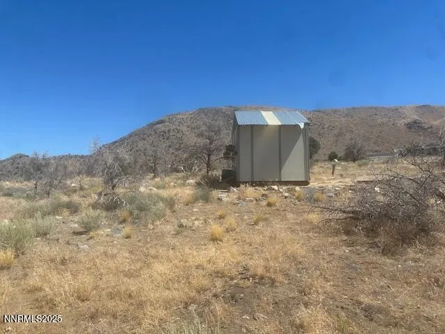 a view of a dry yard with mountains in the background