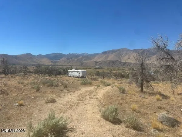 a view of a dry yard with mountains in the background