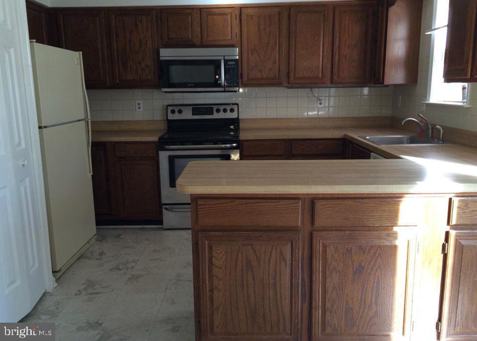 6328 Over See Court Springfield, VA 22152 - Photo 4 of 14 a kitchen with stainless steel appliances a refrigerator a stove a microwave and cabinets
