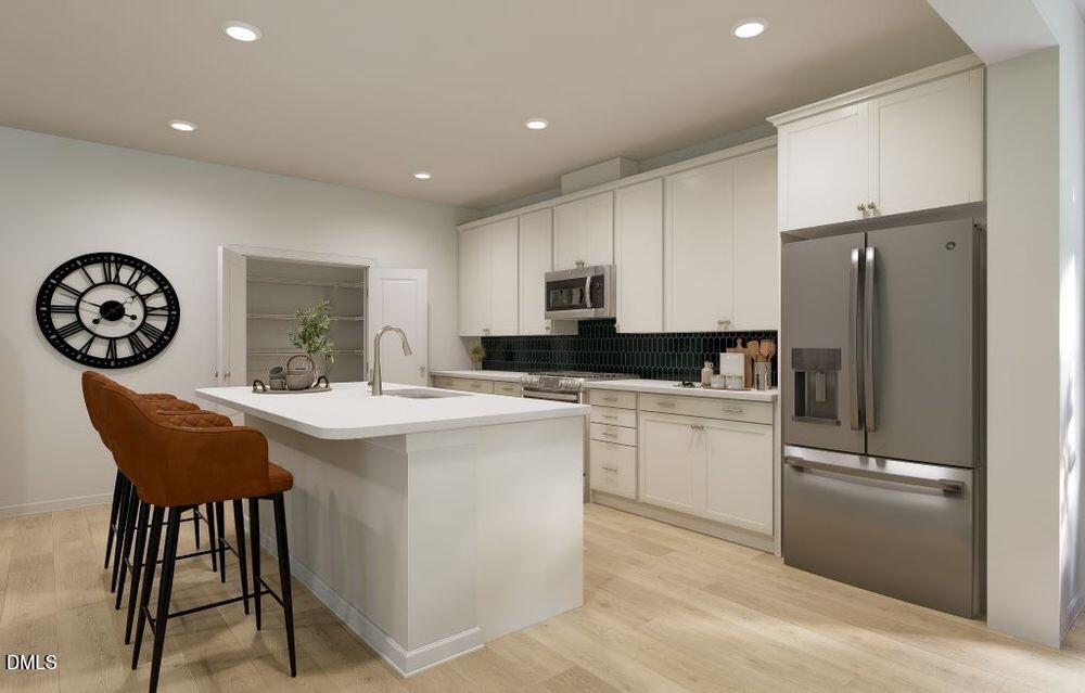 713 Bolera Road Knightdale, NC 27545 - Photo 8 of 35 a kitchen with stainless steel appliances granite countertop a white refrigerator a sink a stove a dining table and chairs