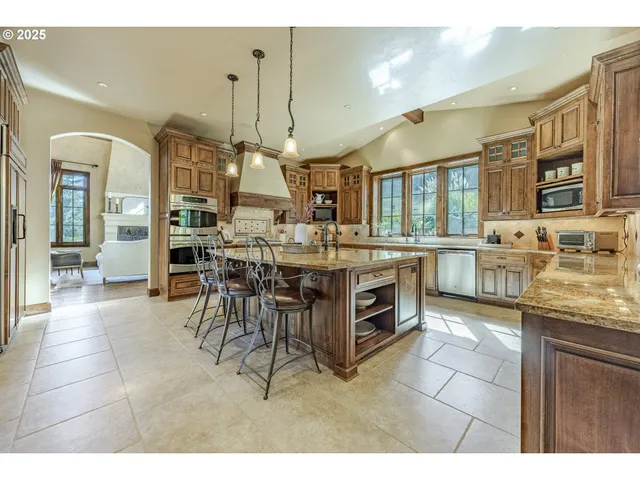 a dining hall with stainless steel appliances kitchen island granite countertop a stove and cabinets