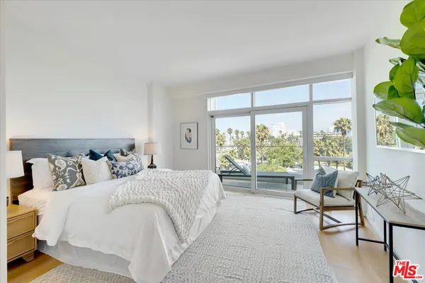 a bedroom with a bed and a large window