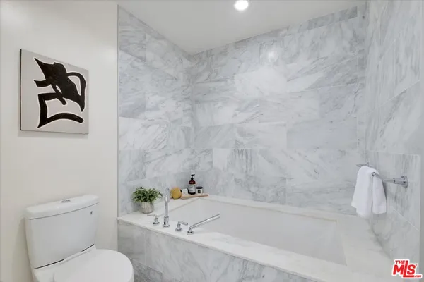 a white bath tub sitting next to a white toilet and sink