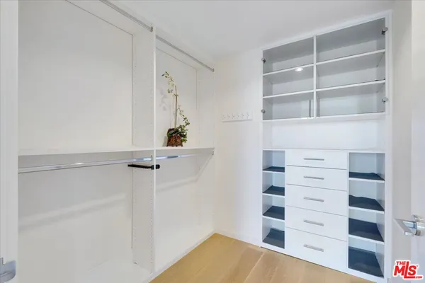 a view of walk in closet with empty racks