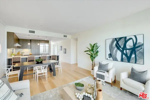 a living room with furniture a rug and a potted plant