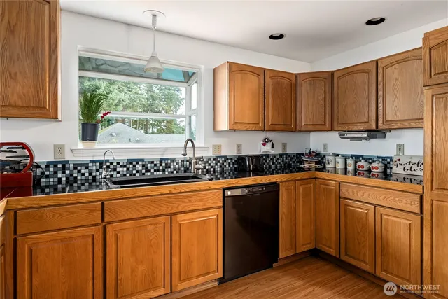 a view of a hallway with wooden floor and a bathroom