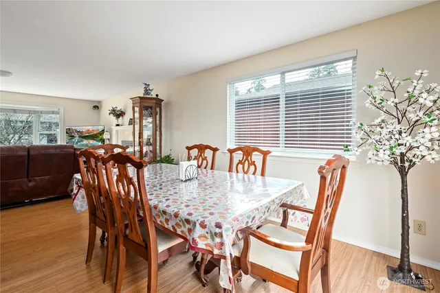 a kitchen with stainless steel appliances granite countertop wooden cabinets a refrigerator a sink a stove and island with wooden floor