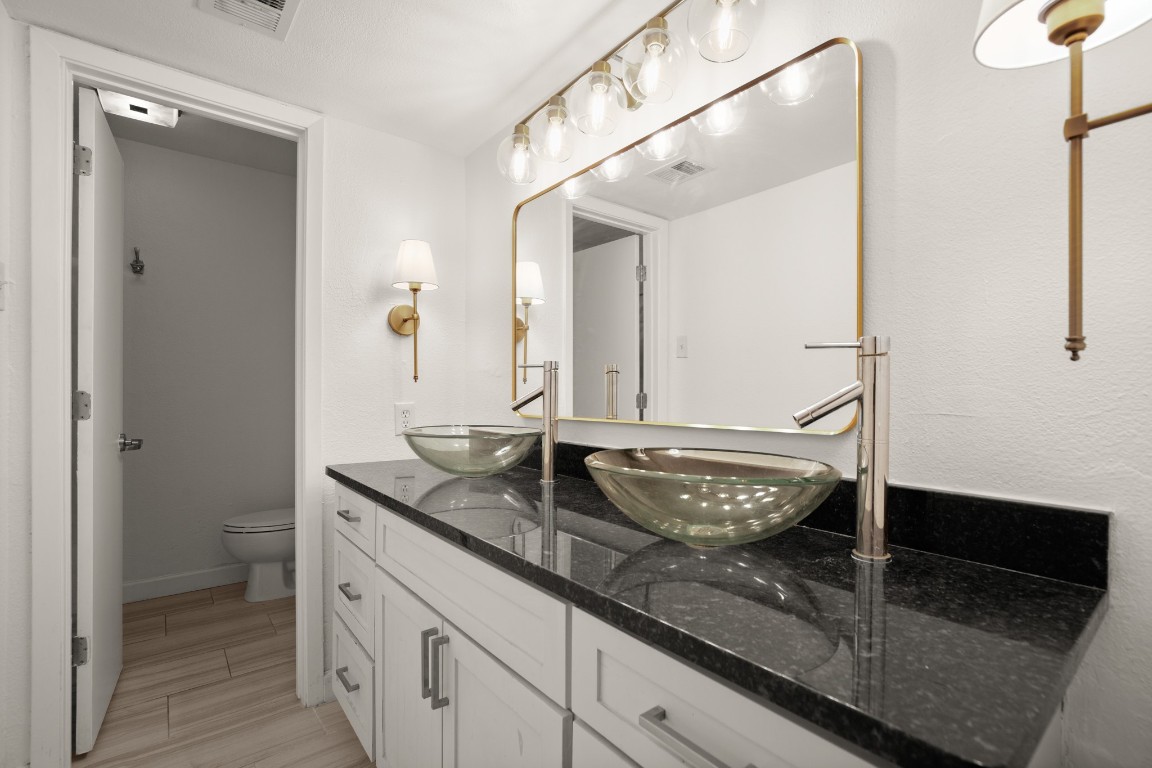 2020 South Congress Avenue, Unit 2102 Austin, TX 78704 - Photo 13 of 22 a bathroom with a granite countertop sink and a mirror