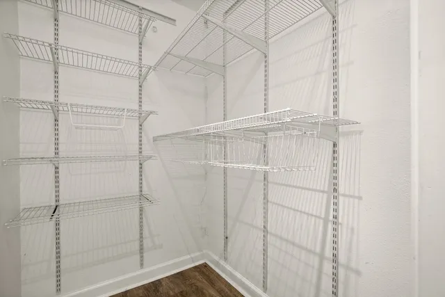 an empty room with wooden floor and window