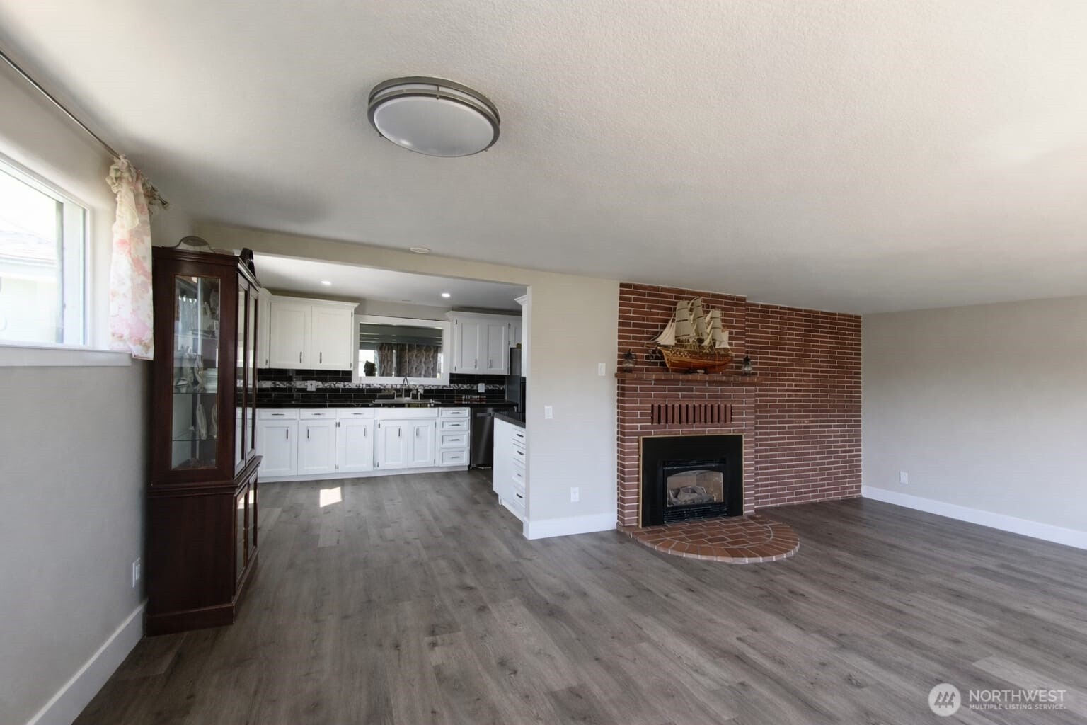 108 West Bartlett Road Lynden, WA 98264 - Photo 4 of 24 a view of kitchen view with wooden floor and a fireplace