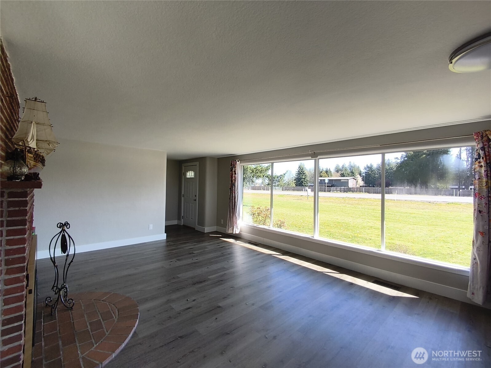 108 West Bartlett Road Lynden, WA 98264 - Photo 6 of 24 a view of an empty room with a window and wooden floor