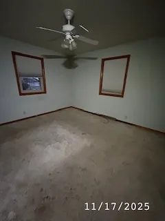an empty room with a ceiling fan and a window