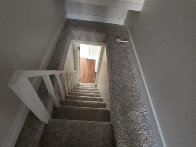 a kitchen with granite countertop a refrigerator stove top oven and sink