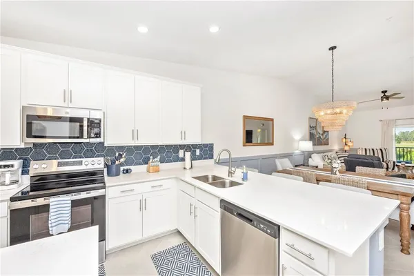 a living room with lots of furniture and a view of kitchen